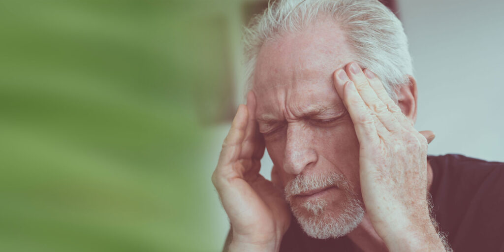 mature man having headache from sleep apnea